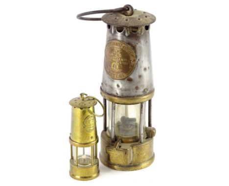 A brass and steel protector miners oil lamp, and a smaller example. (2)
