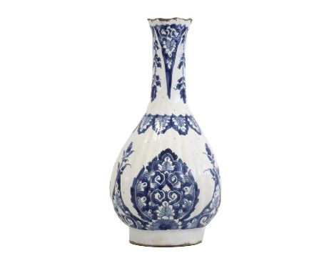 A Delft Bottle Vase, circa 1700, of fluted pear form, painted in blue in Kangxi style with palmettes and pyramid-shaped folia