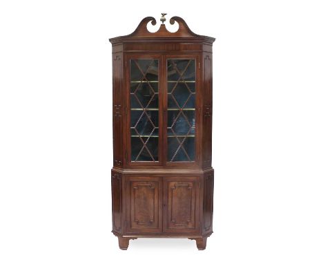 A George III Mahogany Free-Standing Corner Cupboard, attributed to Gillows, late 18th century, the scrolled swan neck pedimen