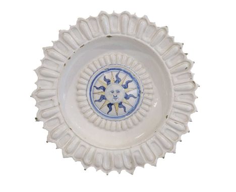 A Delft Charger, 17th century, the central boss painted in blue and ochre with a stylised sun burst within moulded gadrooned 