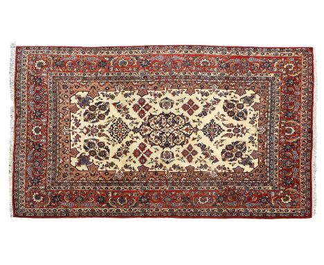 Nejafabad CarpetCentral Iran, circa 1970The cream ground of floral sprays around a scrolled skeletal medallion, enclosed by b