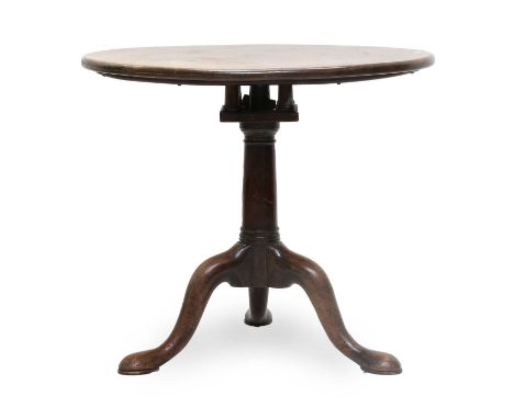 A George II Mahogany Tilt-Top Circular Tripod Table, circa 1750, the one piece top pivoting on a birdcage platform and turned