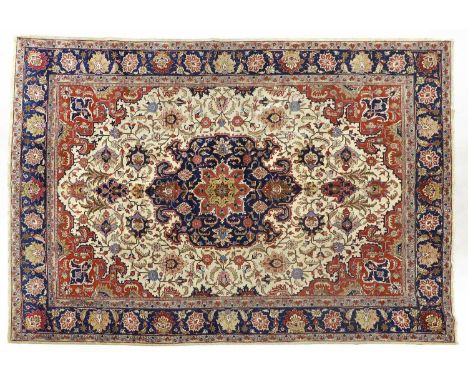 Tabriz CarpetNorth West Iran, circa 1950The cream field of angular vines centred by an indigo and terracotta pole medallion, 