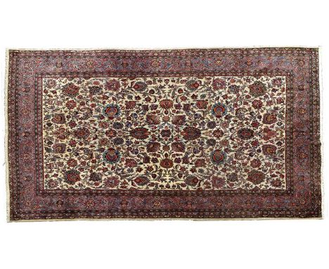 Kashan CarpetCentral Iran, circa 1940The ivory field of large flowerheads and palmettes interspersed with scrolling vines enc