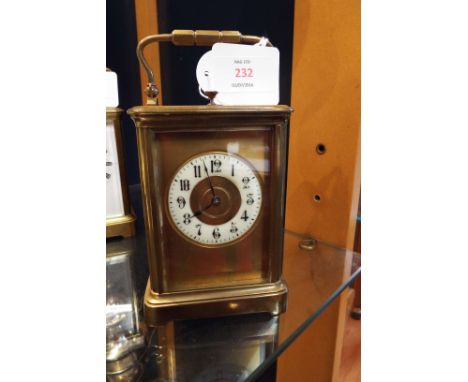 A brass and glass carriage clock with enamelled ring dial and Arabic numerals, having repeater