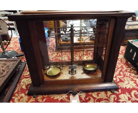 A set of brass balance scales and weights and glass case