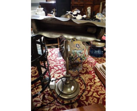 A brass adjustable desk lamp on pedestal base  minor dent in keeping with age, will need re-wiring, baize perished to base,  