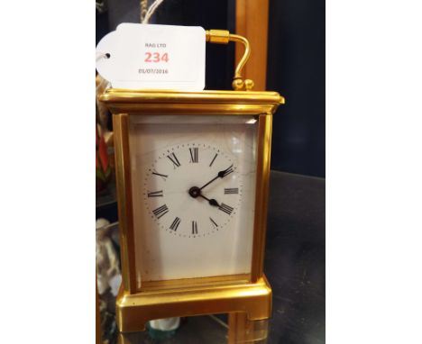 A brass and glass carriage clock and key