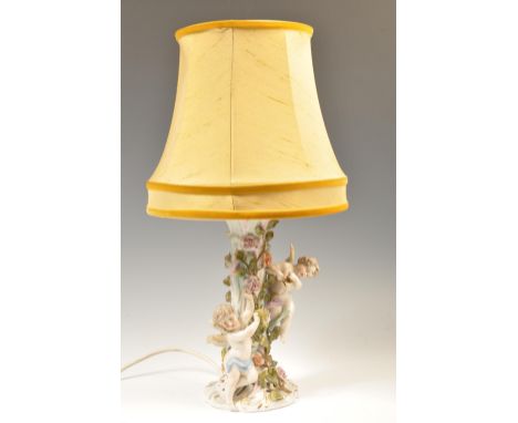 A 19th Century German Sitzendorf floral encrusted winged cherub / putti porcelain table lamp&nbsp; in the form of a floral en