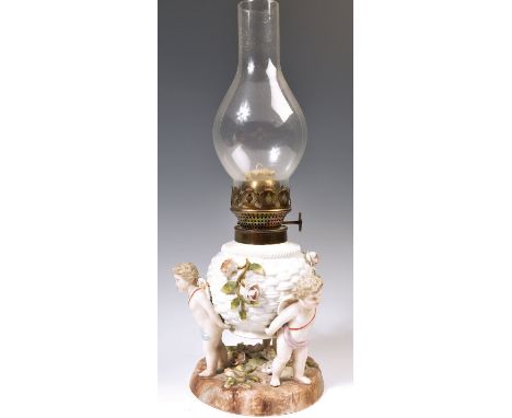 A 19th Century German Sitzendorf floral encrusted winged cherub / putti porcelain oil lamp set over a floral spray embellishe