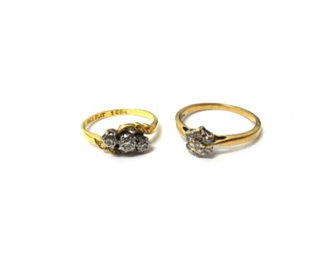 A gold and platinum, diamond set three stone ring, mounted with circular cut diamonds in a crossover design, ring size K and 