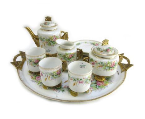 An English porcelain part tea service, late 19th century, decorated with flowers against a white ground, the gilt handles and