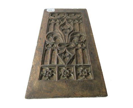 A 17th century French oak blind tracery panel, relief carved with fleurs de lis, 18cm wide x 37.5cm high.