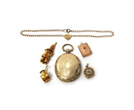 A Victorian oval pendant locket, with engine turned decoration within a moulded border, three 9ct gold charms, comprising; 2 