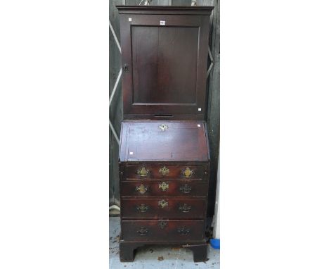 An 18th century oak bureau cupboard of small proportions, with single panel drawer over fitted interior, with four long gradu