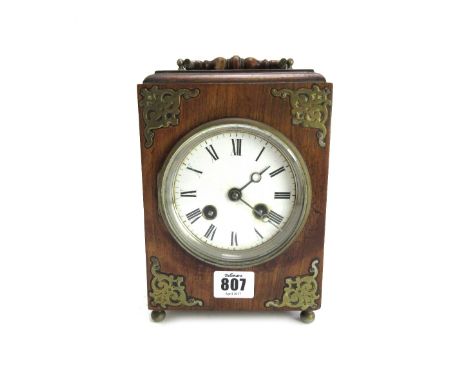 An oak cased mantel clock, late 19th century, with brass embellishments and white enamel dial enclosing a two train movement 