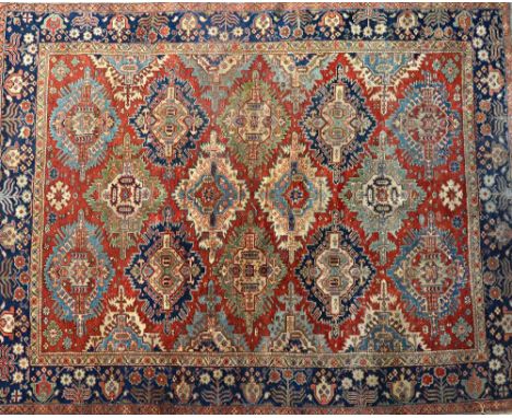 A Tabriz carpet, Persian, the madder field with an allover design of large zejwa (kuba), serrated diamond medallions in sage 