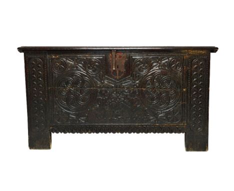 A large 17th century and later Spanish chest, the plank top over a carved front decorated with opposing figures playing horns