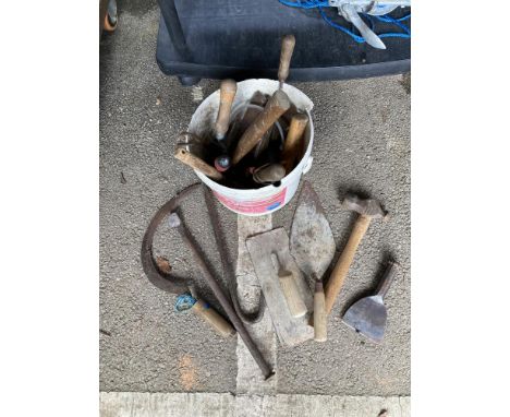 A bucket including cement, plaster floats &amp; other tools