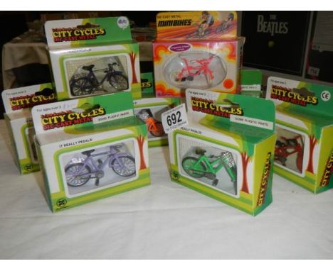 Eight boxed 1/20 scale die cast bicycles.