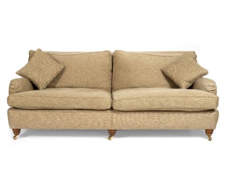 A THREE SEATER GREY UPHOLSTERED SOFA with turned front legs and brass castors 210cm long x 100cm deep x 80cm high