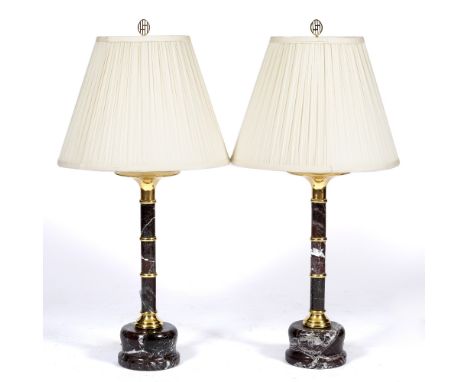 A PAIR OF TURNED MARBLE TABLE LAMPS  with brass mounts and pleated silk shades, the base to each lamp 15cm diameter and the l