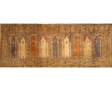 A TURKISH RECTANGULAR WALL HANGING  depicting nine windows with hanging lantern and inscriptions, mounted on a wooden frame, 