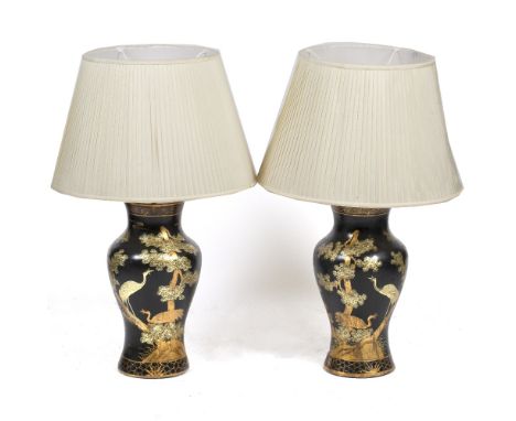 A PAIR OF BLACK LACQUERED CHINOISERIE PAPIER MACHE TABLE LAMPS of baluster form, decorated with scenes of deer and stalks in 