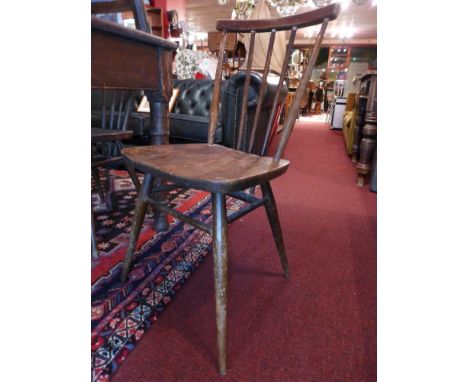 A set of seven elm and beechwood Ercol stick back dining chairs