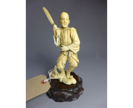 A Meiji period ivory Okimono of a farmer with a sheath on hardwood base