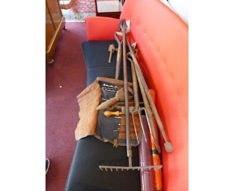 A collection of vintage gardening tools to include a shovel. a pitch fork, a rake etc 