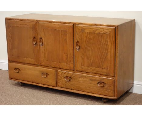 Ercol light elm sideboard fitted with three cupboards and two drawers below, W130cm, H76cm, D44cm