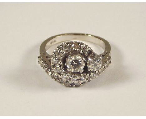 DIAMOND RING. A white 14k. diamond ring of 'swirl' design, the largest stone of approx. 0.4ct spread. Size J/K.