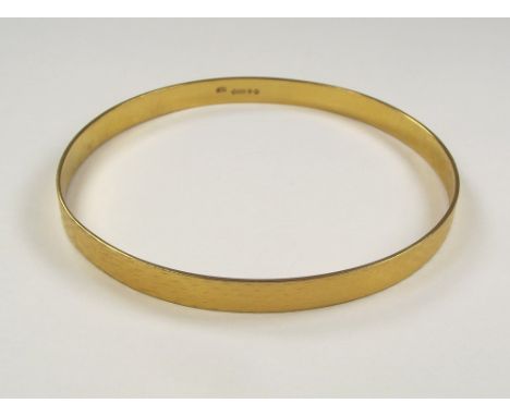 SLAVE BANGLE. A 9ct. gold engine turned slave bangle. London 1924. Approx. 28g.