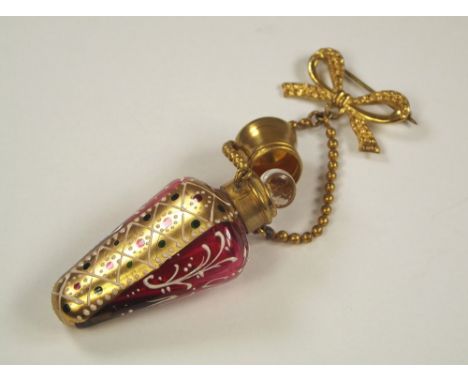 SCENT BOTTLE. A Victorian gilt metal mounted, cranberry glass scent flask with fob brooch. Length 6cm.