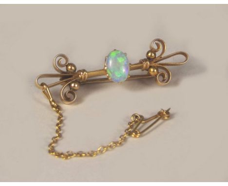 OPAL BROOCH. A Victorian 15ct. gold bar brooch, set a well coloured opal.