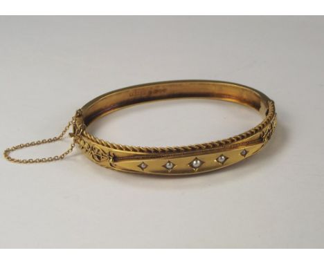 GOLD BANGLE. A Victorian 15ct. gold pearl set hinged bangle. Approx. 14.7g.