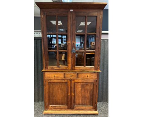 A contemporary dark wood dresser the cornice above two glazed panel doors opening to shelved interior, the lower with three s
