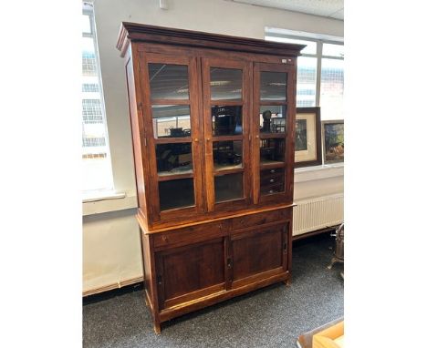 A Contemporary dark wood dresser the moulded cornice over three glazed panel doors opening to shelved interior, the lower wit