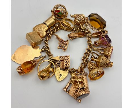 A Heavy antique 9ct yellow gold charm bracelet fitted with a collection of 9ct yellow gold charms, also includes an 18ct yell