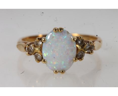 18ct gold opal and diamond ladies dress ring, the central cabochon opal in claw setting each side flanked by three smaller di