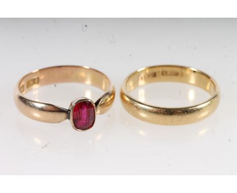 18ct yellow gold wedding band of plain form, size R, 5.5g and a yellow gold faceted red gemstone set dress ring, size T, 3.8g