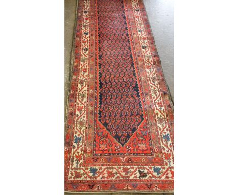 Hamadan runner, indigo ground, repeated rows of boteh ornament, serrated border with tomato ground and spandrels, stylised or