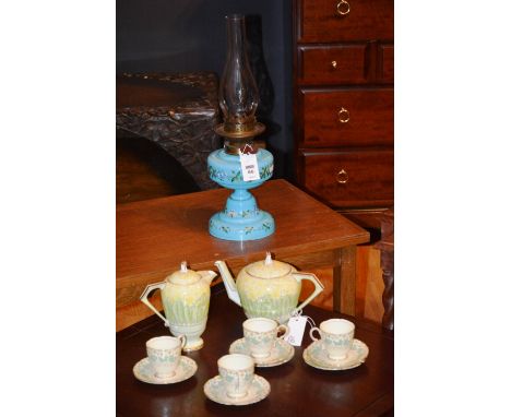 A Victorian oil lamp, with glass funnel above blue opaque glass reservoir and base, hand painted with floral panels, together