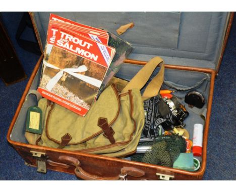 A large quantity of fishing tackle and accessories, to include reels, net, magazines etc, in a vintage suitcase