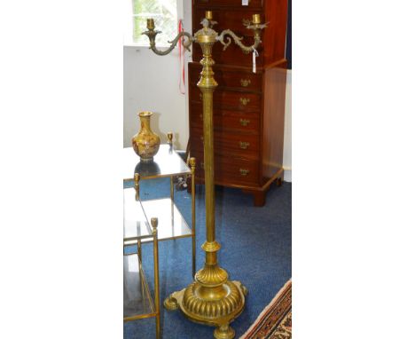 A late Victorian brass floor lamp, with three branch candle sconces to the top, above reeded column support, ending in circul