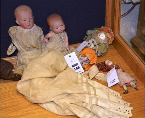 A small Armand Marseille bisque headed doll, in the form of a baby wearing a gown, 21cm long, together with a similar German 