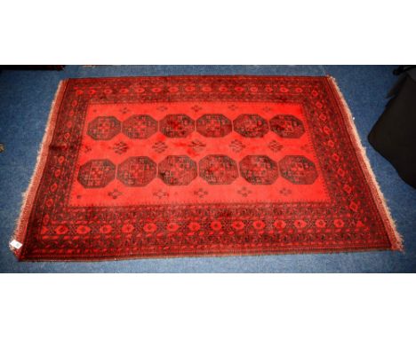 A fine Afghan carpet, with two rows of six medallions over red ground and borders, 228 x 159cm