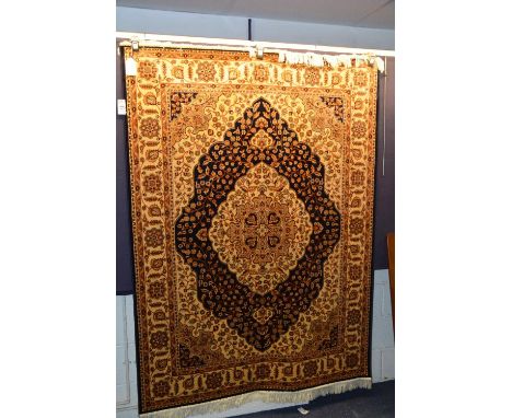 A Kum wall hanging/carpet, the central medallion with allover foliate design, the blue ground ground with cream spandrels and