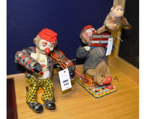 Two vintage tin plate battery operated clown figures, one playing a fiddle, the other holding a monkey playing the symbols, 3